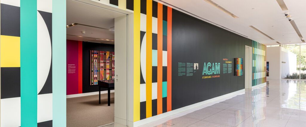 Exhibition hallway decorated with colorful walls and wall hangings by artist Yaacov Agam for 2020-2022 exhibition