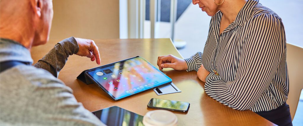 Multiple smart devices sit between two people conversing