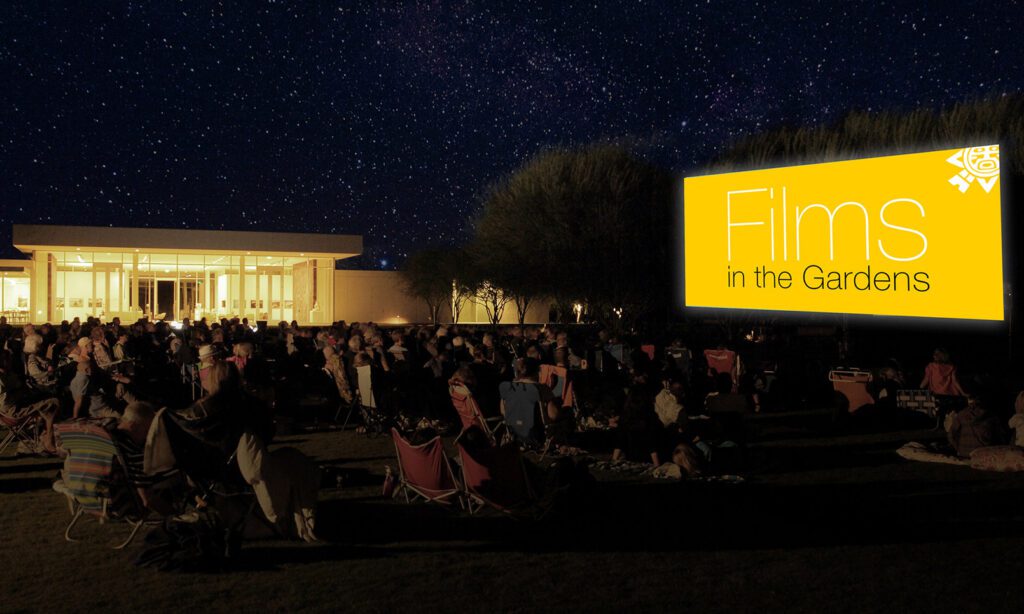 Films in the Gardens graphic on a big screen on the Great Lawn at night