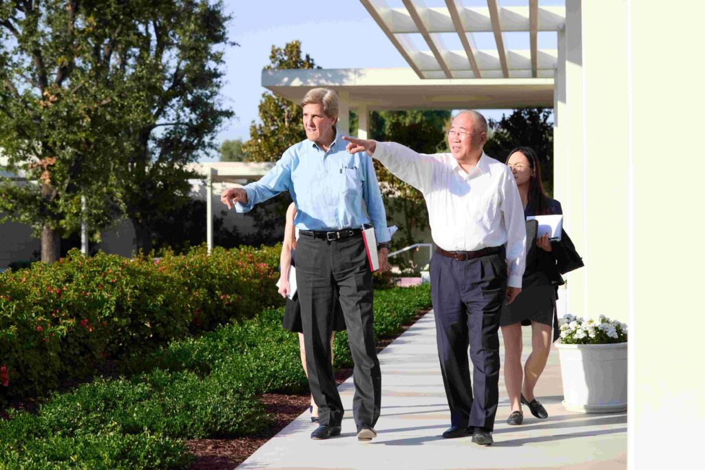 Former Secretary of State John Kerry, the U.S. Special Presidential Envoy for Climate, and his counterpart from China, Minister Xie Zhenhua, walk along the west terrace of the Sunnylands estate.